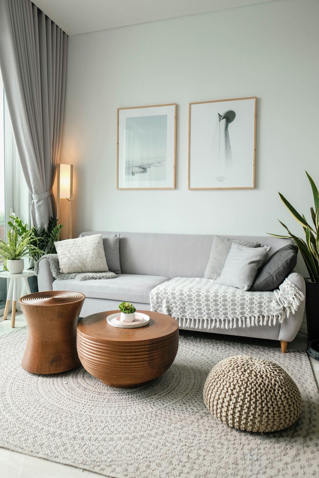 A calm room with a light grey sofa, wood side tables and soft lamp light